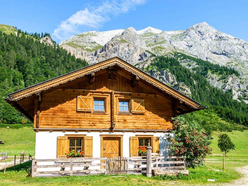 Lesena podeželska hiša, ki jo krasijo lesena masivna vrata, je značilna za alpski svet.