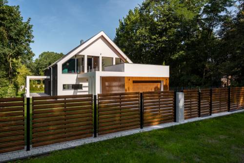 Pogled na krasno leseno ograjo, ki se lepo sklada s hišo in njeno
            okolico.