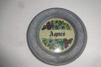 Majhen krožnik iz cinka, v sredini cvetlični vzorec in napis Agnes