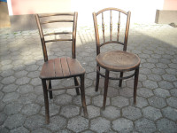 Dva lesena starinska stola rjave barve še uporabna za okras ali muzej.