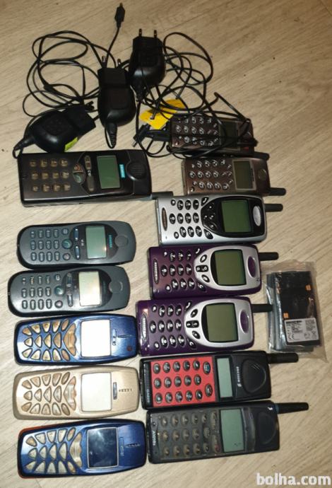 Stari mobilni telefoni, delujoči prenosnik, polnilci, adapte